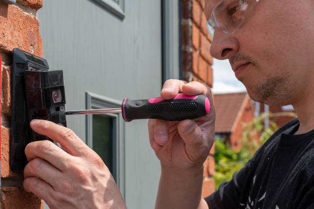 Installing a smart doorbell with security camera Man installing a smart doorbell with security camera and solar charger next to the front door of his house doorbell photos stock pictures, royalty-free photos & images