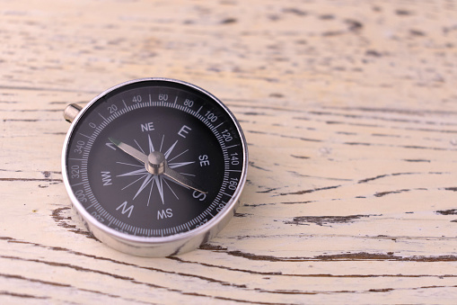 Classic round compass on white  wooden vintage background. Travel concept. Copy space.
