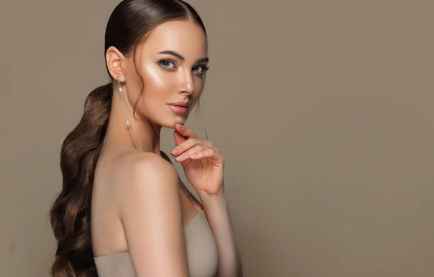 retrato de una mujer de pelo castaño joven de aspecto perfecto con el pelo largo, con un maquillaje exquisito. peinado y maquillaje. - vestido de noche fotografías e imágenes de stock