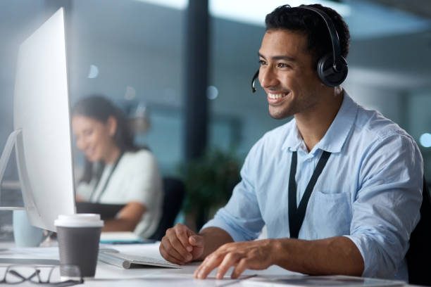 istock Shot of a young man using a headset and computer in a modern office 1329866234