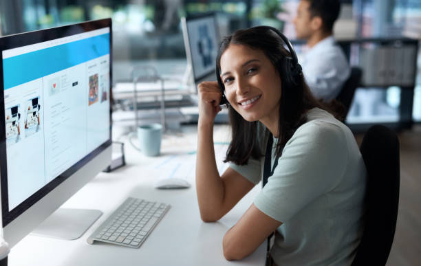 istock Portrait of a young woman using a headset and computer in a modern office 1329866367