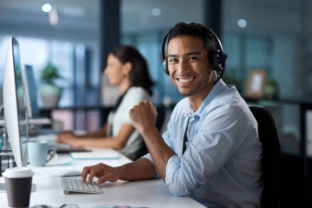 istock Portrait of a young man using a headset and computer in a modern office 1329866395