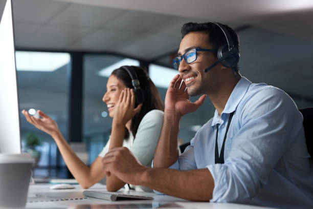istock Shot of a young man using a headset and computer in a modern office 1329866410