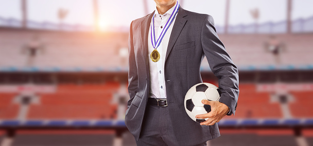 Businessman hanging around neck with Gold medals in hands with smart suit. Concept for success