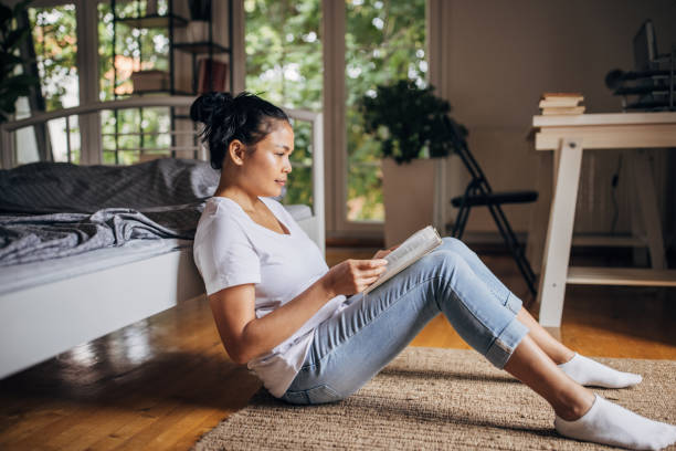 istock Woman reading a book in bedroom 1329866987