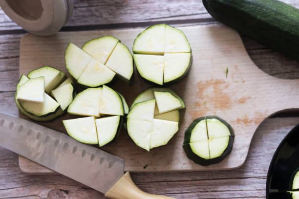 istock cutting zucchini with a knife on a wooden cutting board. 1329870065