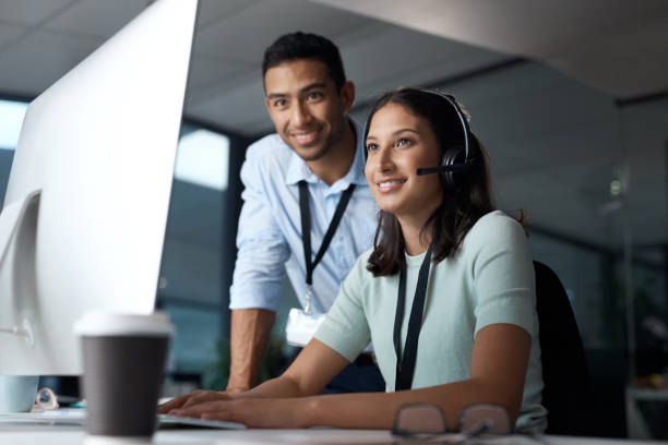 istock Shot of a young man and woman using a computer while working in a call centre 1329870145
