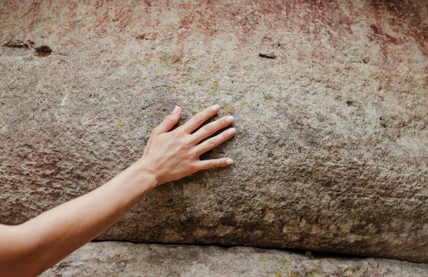 istock Woman hand touching the rock surface 1329872431