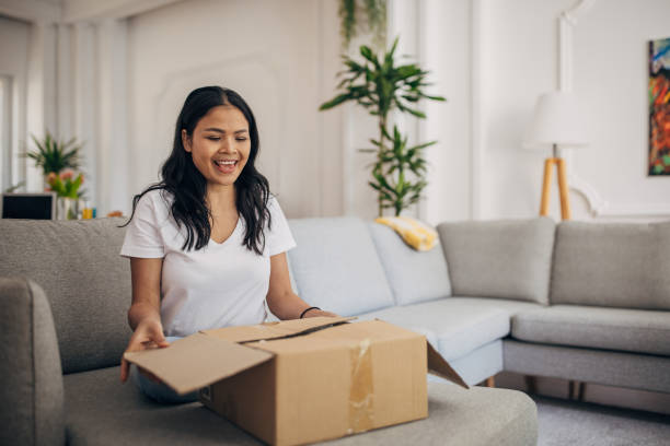 istock Woman opening a package at home 1329874709
