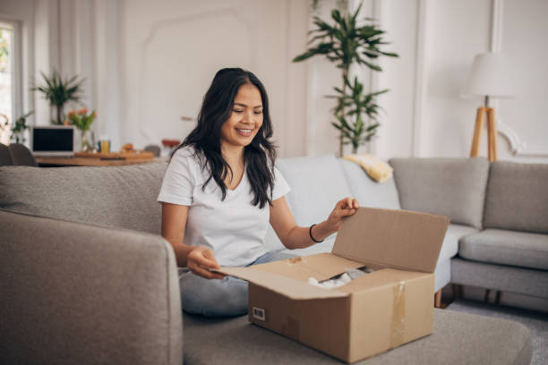 istock Woman opening a package at home 1329874793