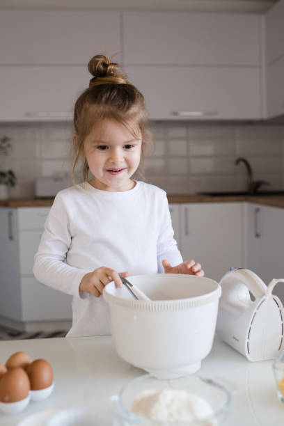 istock Cute kid girl cook at home kitchen 1329876167