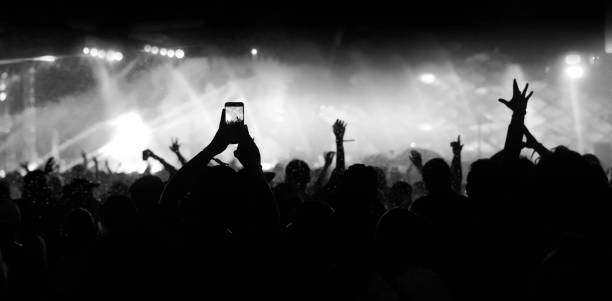 istock The crowd at a concert. Fun, hands up. Black and white technic. 1329876176