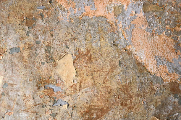 gealterte verfallsoberfläche einer wand mit gebrochener abstrakter textur und oranger lachsfarbe im hintergrund - beschädigte tapete - unstuck stock-fotos und bilder
