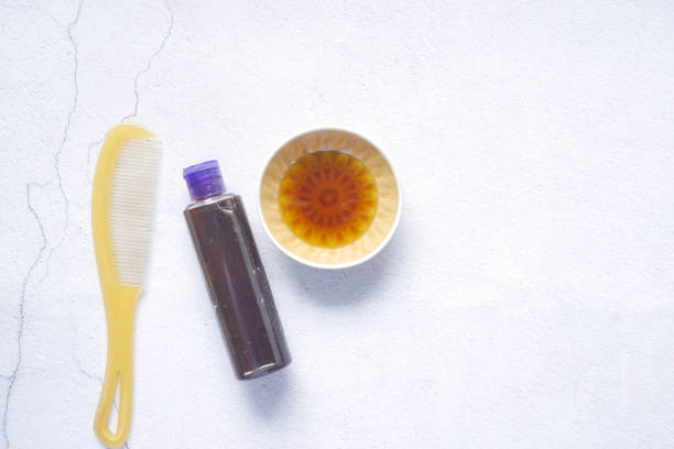 istock hair oil, comb and container on table , top view , 1329878131