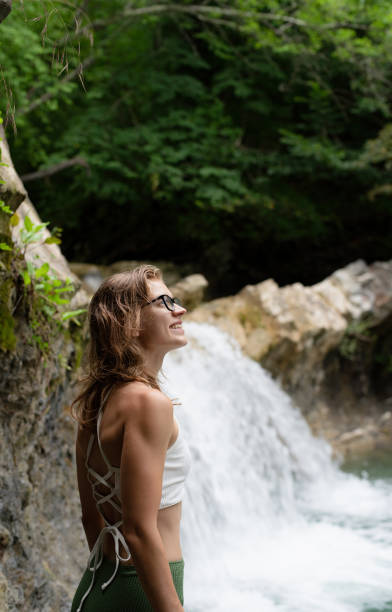 istock Young happy woman enjoing the waterfall 1329879391