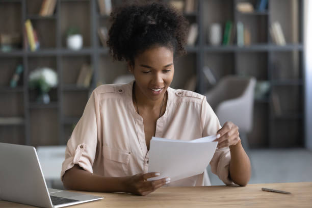 istock Smiling African American woman working with documents, sitting at desk 1329881322
