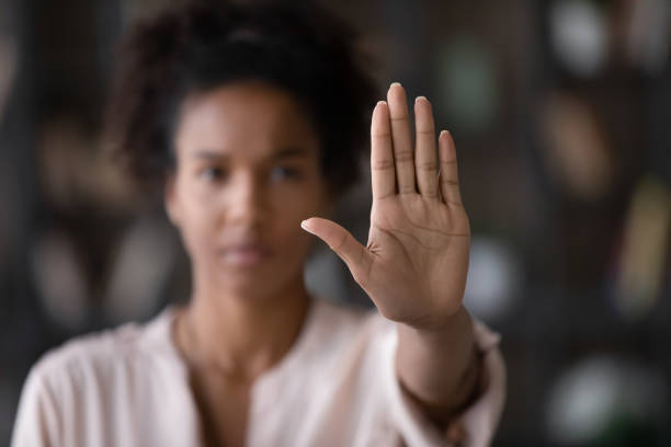 nahaufnahme afroamerikanische frau, die stoppgeste mit der hand zeigt - vorurteil stock-fotos und bilder