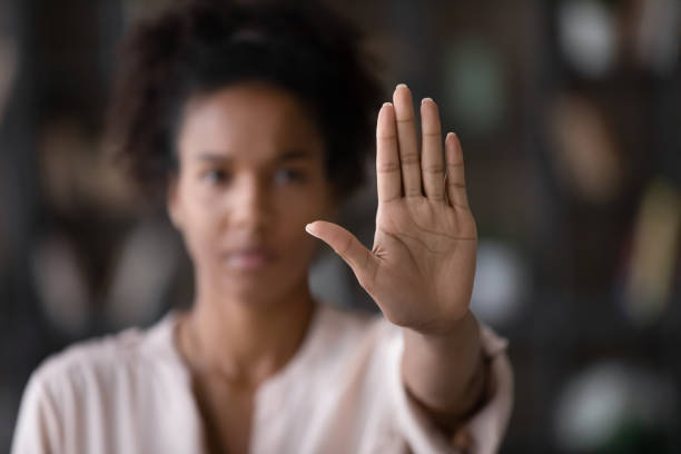 Close up African American woman showing stop gesture with hand Close up of African American woman showing stop gesture with hand blurred background, young female protesting against domestic violence and abuse, bullying, saying no to gender discrimination prejudice stock pictures, royalty-free photos & images