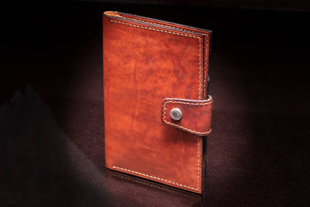 istock Leather wallet brown wallet with a button fastener on a dark background. 1329883984