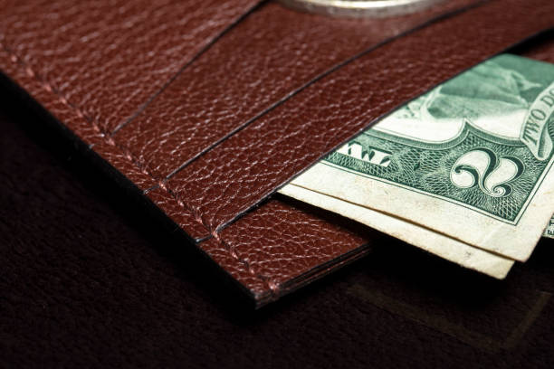 istock Part of a leather wallet or wallet with a banknote on a dark background. 1329884136