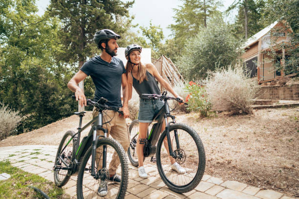 happiness couple with mountain ebike outdoors - electric bicycle imagens e fotografias de stock