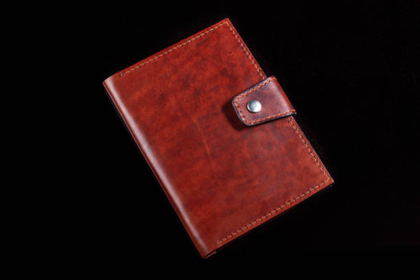istock Leather wallet brown wallet with a button fastener on a dark background. 1329889048