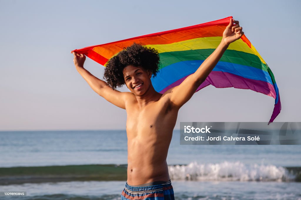 Young latino man with afro hair showing lgtbi flag Protest Stock Photo