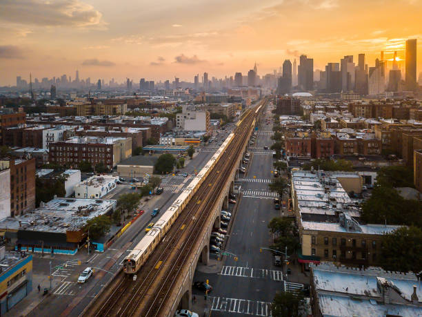 Train passing trough Sunnyside Queen during sunset in New York, USA Subway train going trough Sunnyside Queens during sunset on a cloudy summer day. New York aerial skyline in the United States of America queens new york city stock pictures, royalty-free photos & images