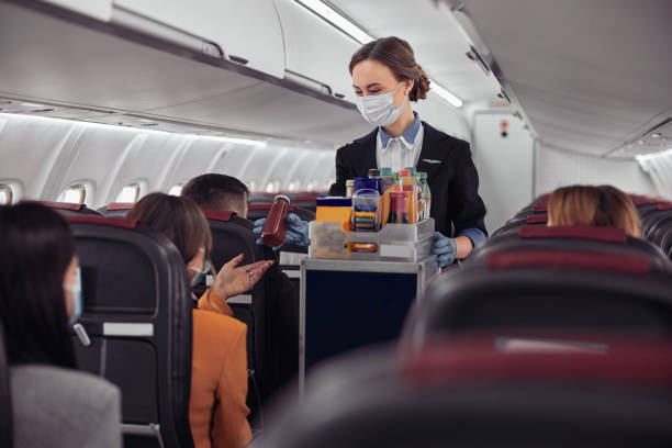 istock Stewardess giving bottle with drink to passenger 1329895238