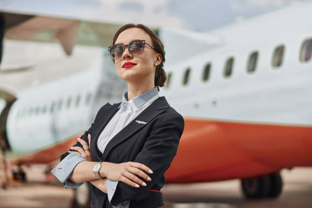 istock Thoughtful stewardess on runway near airplane jet 1329895373