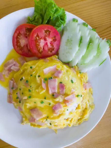 Photo of Jasmine rice with ham soft omelet served with the tomato and cucumber sliders.
