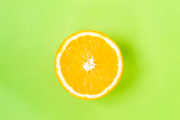 istock Top view of one orange round fruit on bright green background. Rich citrus texture. Copy space 1329897802