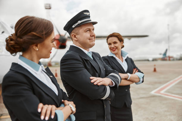 istock Pilot and stewardesses on runway near airplane jet 1329897963