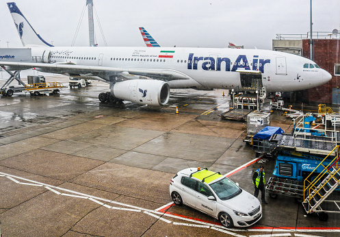 2018_01_02_London UK IranAir passenger jet airplane being filled with supplies at Heathrow Airport on a rainy day.