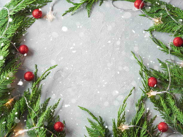 istock Green fir tree branches frame with star shape Christmas lights and red ornament decor 1329900262