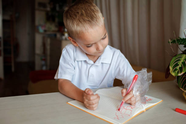 Happy left-handed boy put his left hand in plastic glove to avoid messy, international left-hander day celebration, only lefties understand