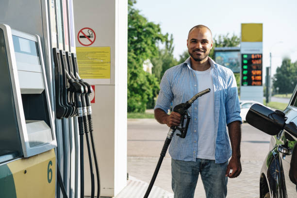 man filling gasoline fuel in car at gas station - gas station fuel pump station gasoline imagens e fotografias de stock