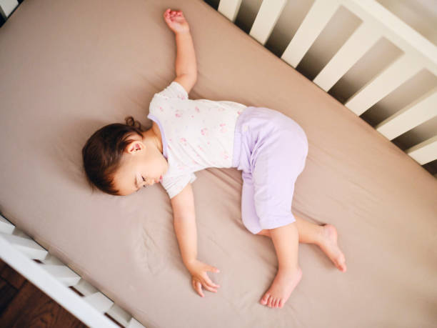 bebé durmiendo en una cuna - cot fotografías e imágenes de stock