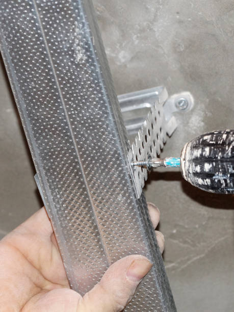 istock male hand with screwdriver fastening profile for suspended plasterboard ceiling 1329905492