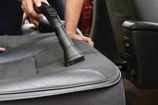 istock Man vacuum cleaning his car seats interior 1329905602