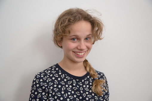 Smiling teenager girl with blond hair, blues eyes and braided hair