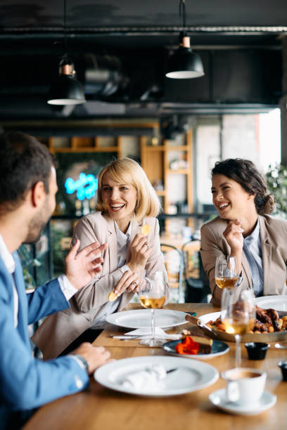 istock Cheerful business colleagues enjoying in conversation while having lunch in a restaurant. 1329913201