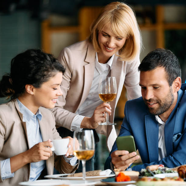 istock Happy business colleagues using smart phone  in a restaurant. 1329913292