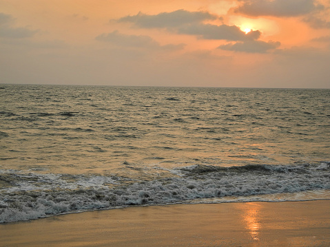 Sunset on the background of the gray foaming waves of the Arabian Sea. Travel concept