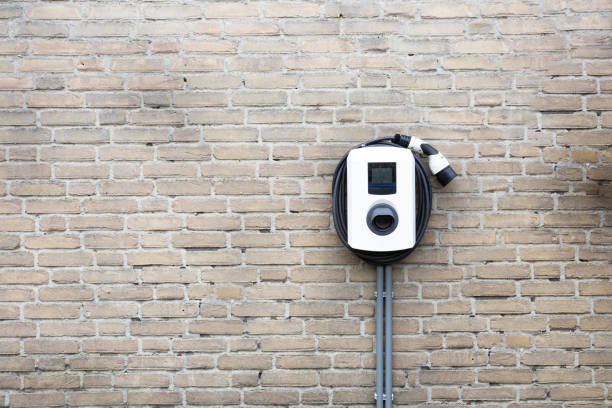 New charging station for electric car on brick wall at home, charging pillar with copy space , stock photo