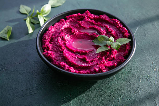 istock Humus Bowl. Red beetroot hummus with fresh vegetables, olive oil on table 1329916046