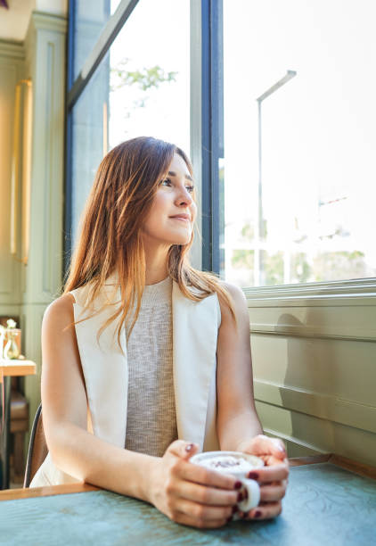 istock Beautiful woman drinking a coffee in a bar 1329916471