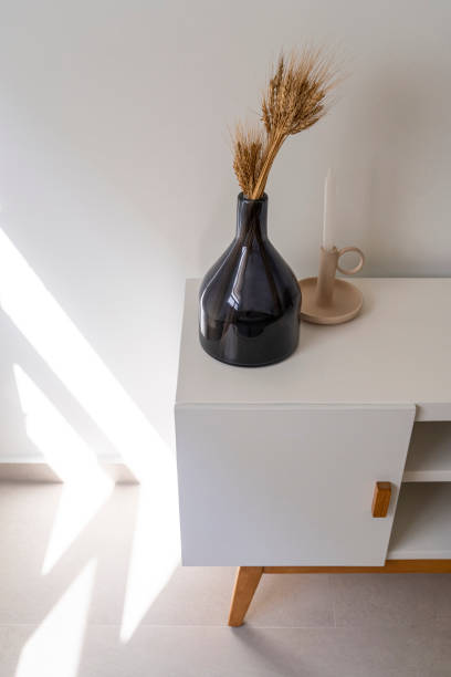 istock Home accent decor, dark glass bottle, modern, candle holder, candlestick over white console table 1329917367
