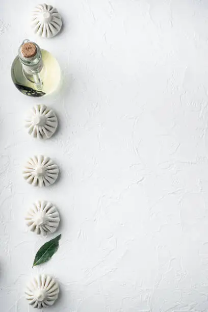 Photo of Manti or manty dumplings, popular asian dish, on white stone  surface, top view flat lay, with copy space for text