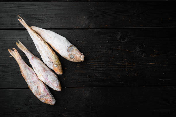 istock Frozen Goatfish raw fish, on black wooden table background, top view flat lay , with copy space for text 1329919935
